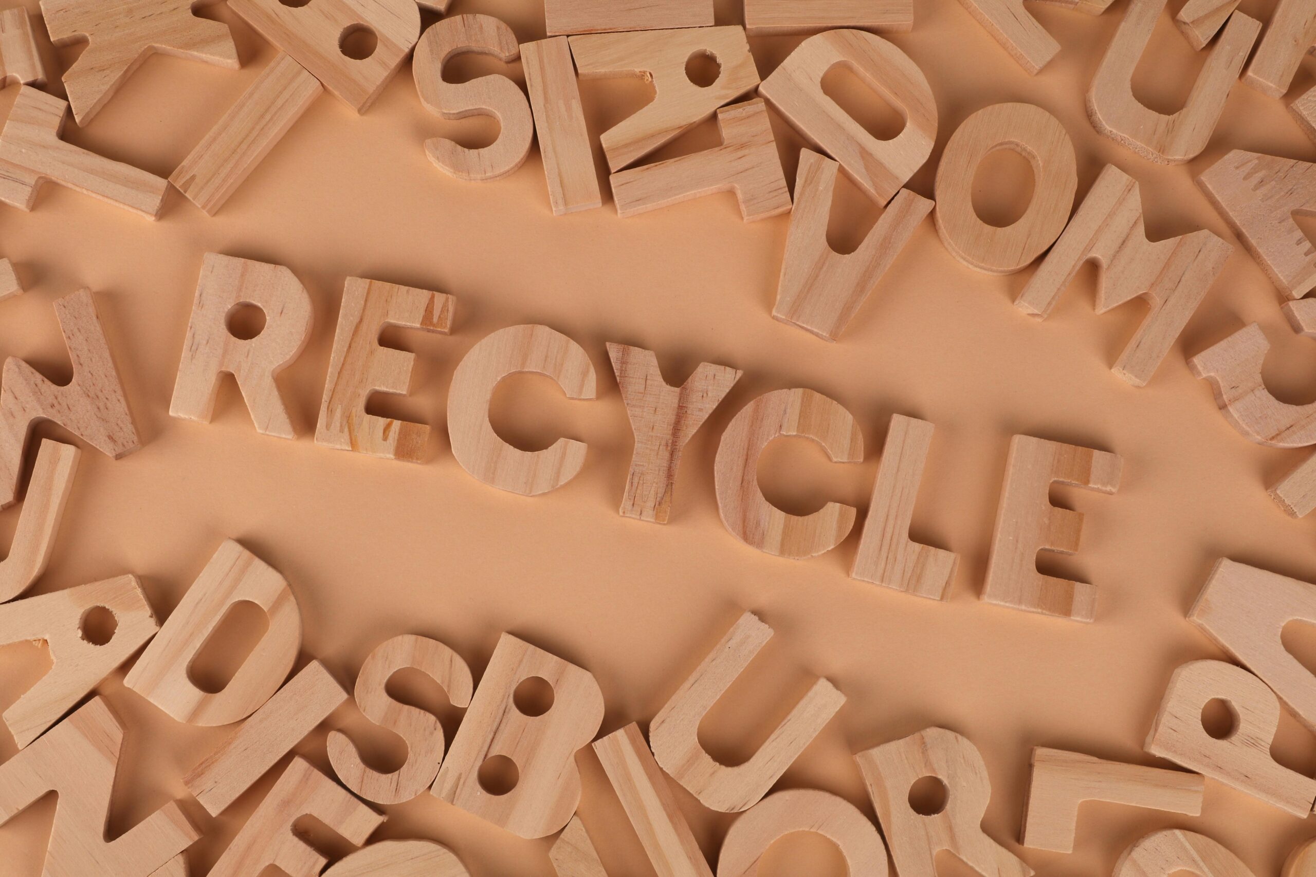 Wooden letters arranged to spell 'recycle', promoting sustainability and eco-friendliness.