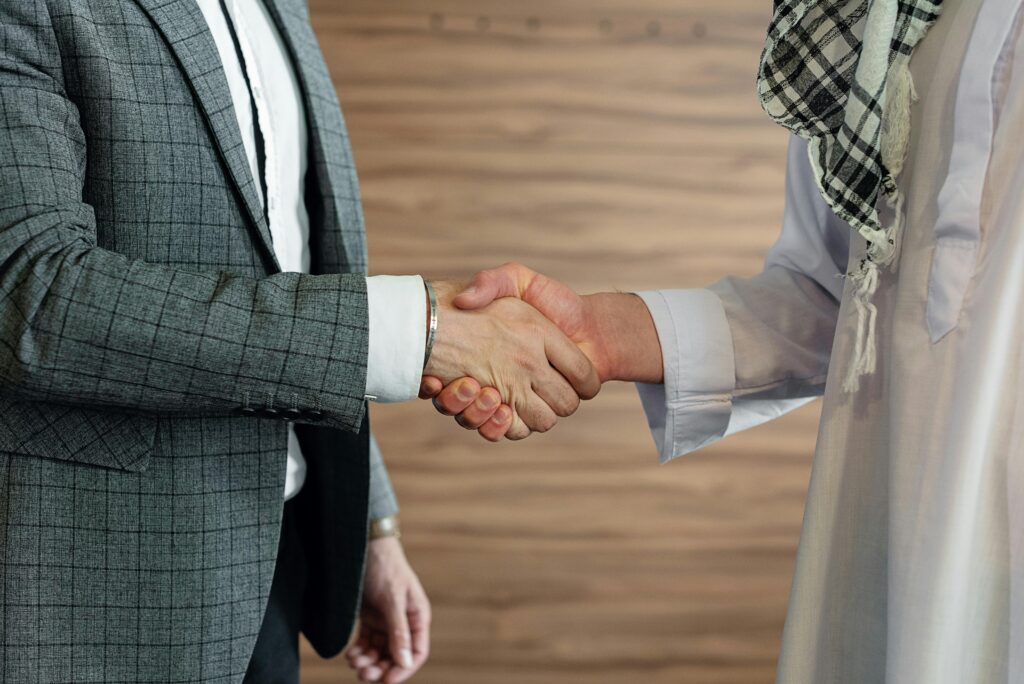 Close-up of a handshake between two men in business attire, symbolizing cooperation and partnership.